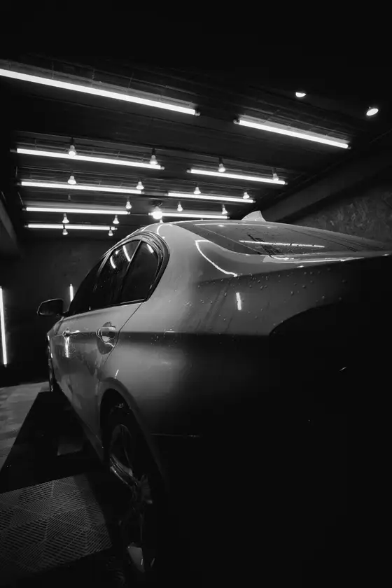 A sedan under the shop lights, mid-detail